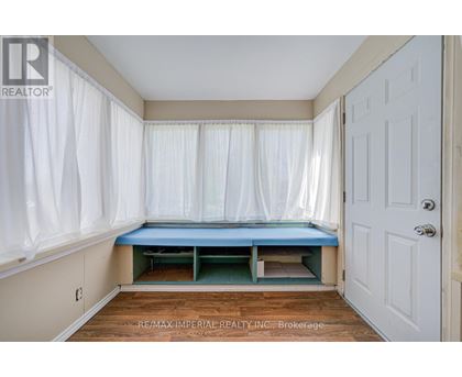 A bedroom with a bed in the corner and a white door.