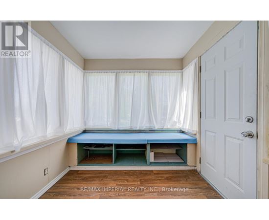 A bedroom with a bed in the corner and a white door.