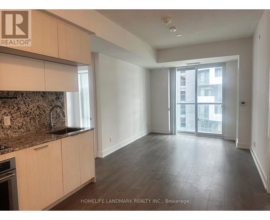 A spacious kitchen with wooden cabinets and a granite countertop.