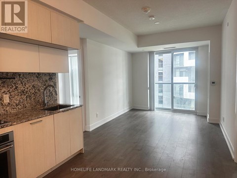 A spacious kitchen with wooden cabinets and a granite countertop.