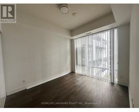 A room with a sliding glass door leading to a balcony.