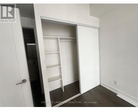A white closet with shelves and a door.