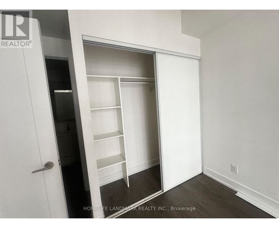 A white closet with shelves and a door.