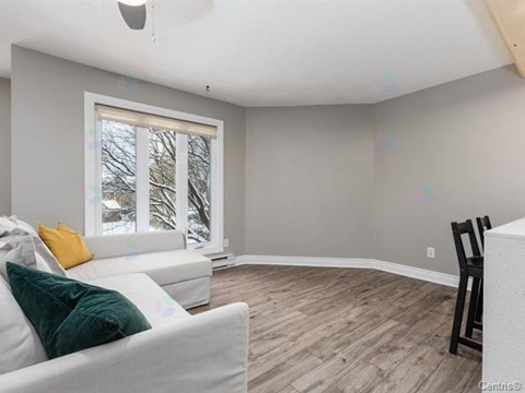 A living room with a white couch and a wooden floor.