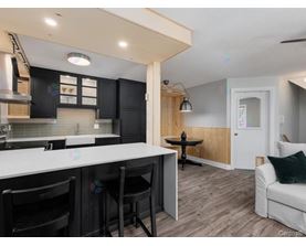 A kitchen with black cabinets and a white countertop.