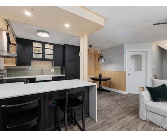 A kitchen with black cabinets and a white countertop.