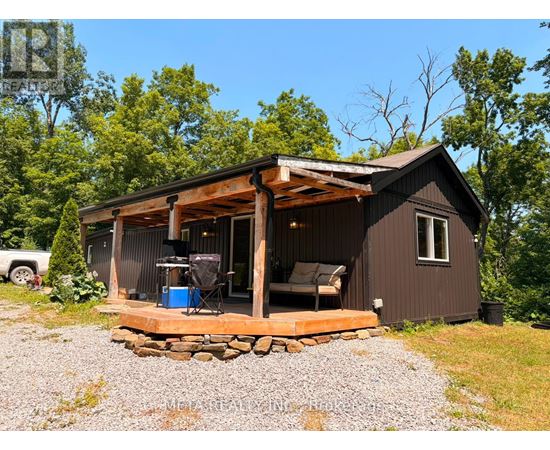 A small cabin with a deck and a covered entrance.