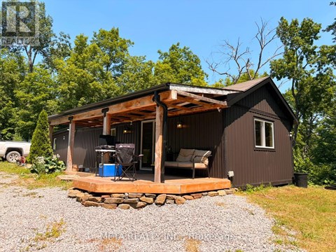 A small cabin with a deck and a covered entrance.