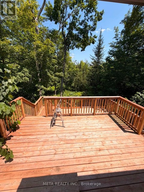 A wooden deck with a chair and a table in the middle of it.