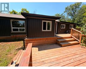 A wooden deck with a house in the background.