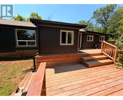 A wooden deck with a house in the background.