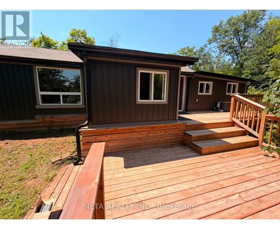 A wooden deck with a house in the background.