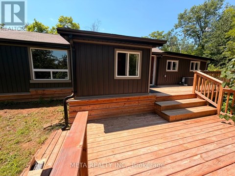 A wooden deck with a house in the background.