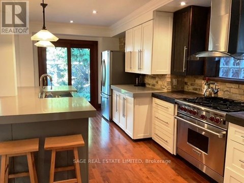 A kitchen with white cabinets and a wooden island.