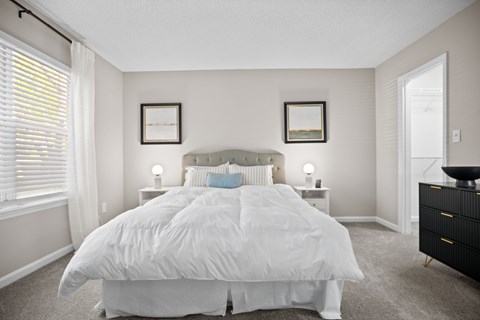 A bedroom with a large bed and two nightstands.