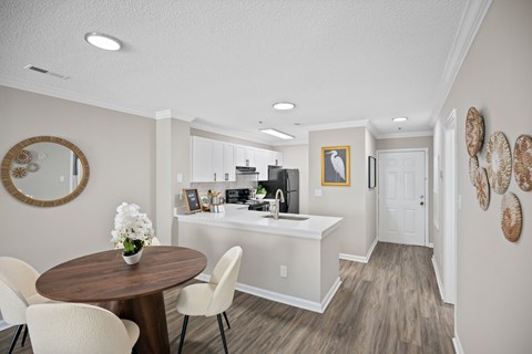 A kitchen with a table and chairs and a sink.
