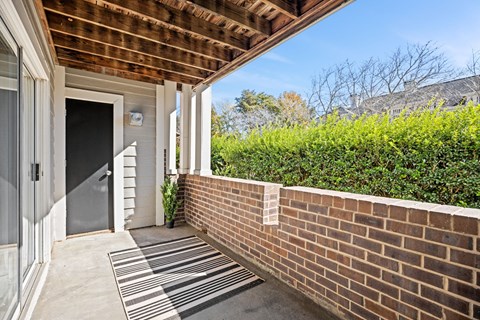 A house entrance with a striped rug on the concrete floor.