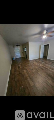 A room with wooden flooring and white walls.