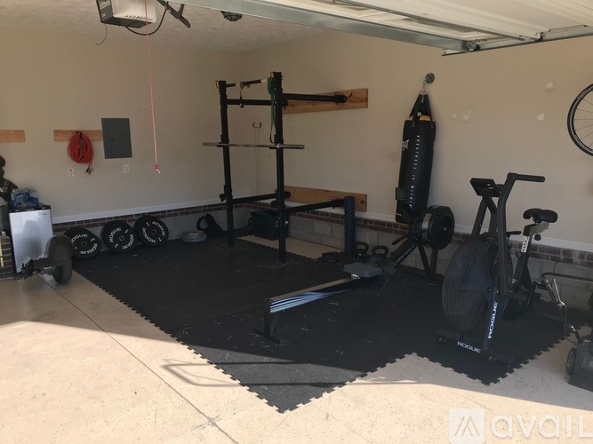 A home gym with a weight rack, a punching bag, and a treadmill.