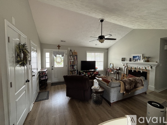 A living room with a couch, a television, and a fireplace.