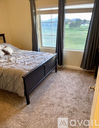A bedroom with a large bed and a carpeted floor.