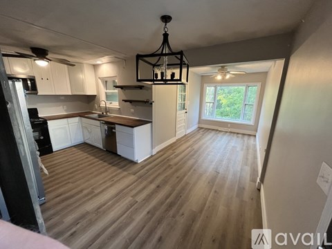 A kitchen with wooden floors and white cabinets is available for rent.