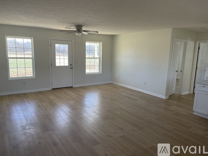 A room with wooden flooring and a ceiling fan.