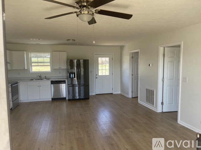 A kitchen with a refrigerator, sink, and cabinets.