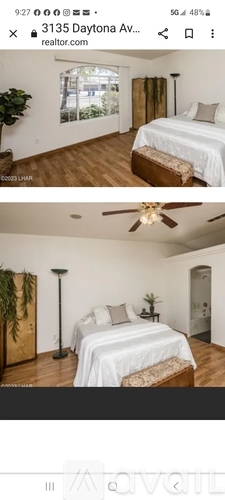 A bedroom with a bed, a ceiling fan, and a window.