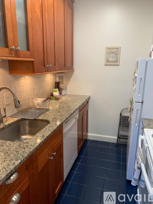 A kitchen with wooden cabinets and a white refrigerator.