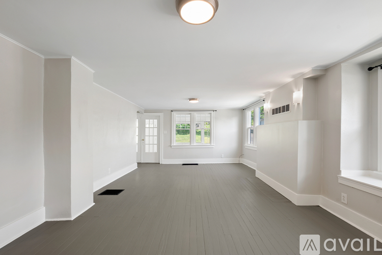 A spacious room with a large window and a door leading to a balcony.