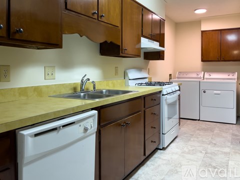 A kitchen with brown cabinets and white appliances.