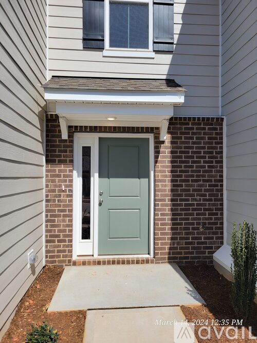 A white house with a green door and a small window above it.
