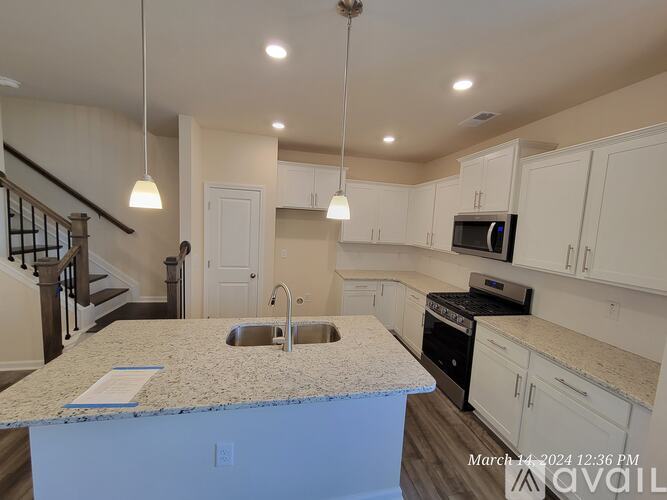 A kitchen with a granite countertop and white cabinets.