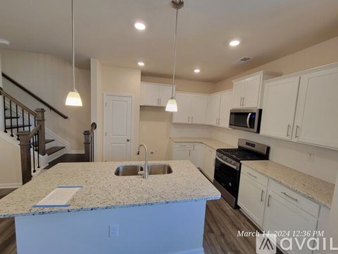 A kitchen with a granite countertop and white cabinets.