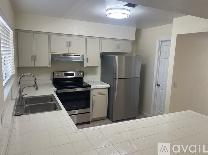 A kitchen with white cabinets and appliances.