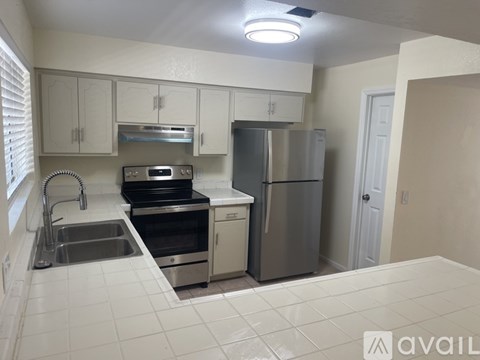 A kitchen with white cabinets and appliances.
