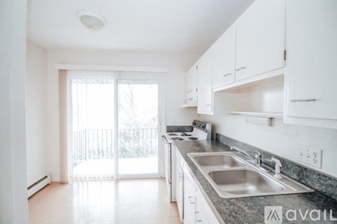 A kitchen with white cabinets and a marble countertop.