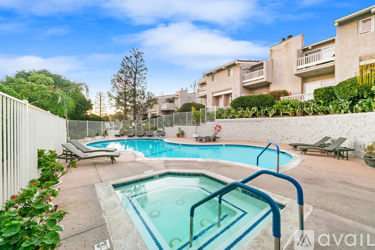 A pool surrounded by a fence and chairs.