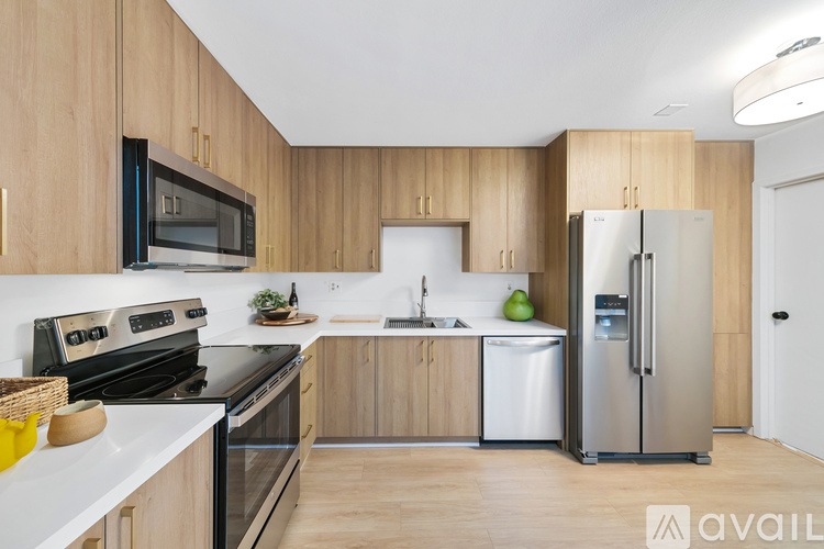 A kitchen with wooden cabinets and a stainless steel refrigerator.