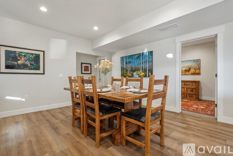 A dining room with a wooden table and chairs.