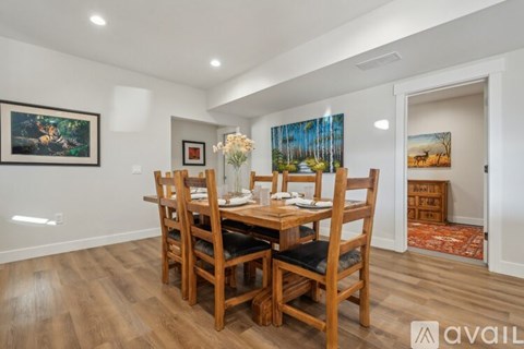 A dining room with a wooden table and chairs.
