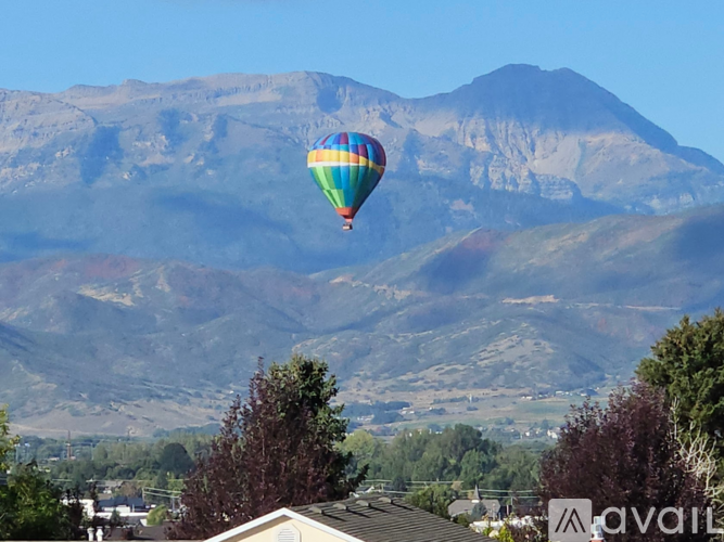 A hot air balloon flies over a mountain range.