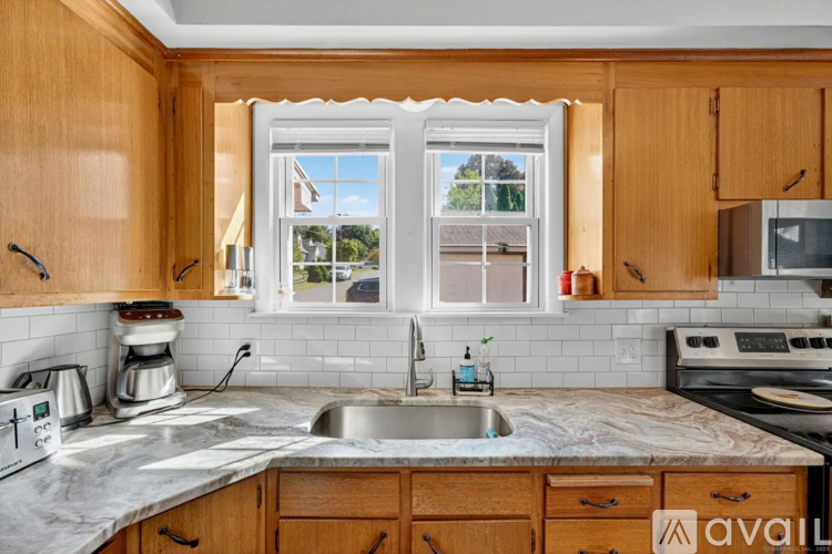 A kitchen with wooden cabinets and a marble countertop.