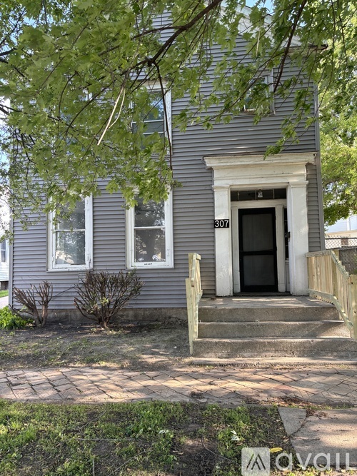 A small house with a black door and a porch.