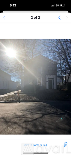 A sunny day with a building and a tree in the background.