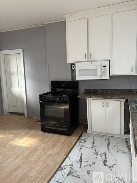 A kitchen with a black oven and white cabinets.
