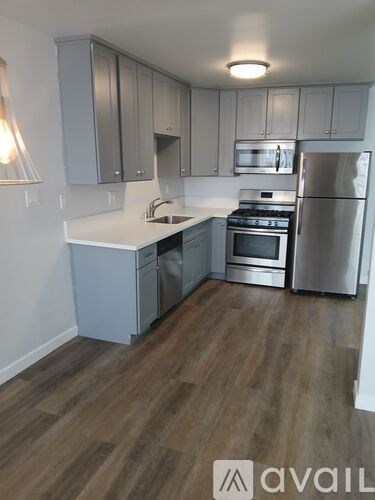 A kitchen with wooden floors and stainless steel appliances.