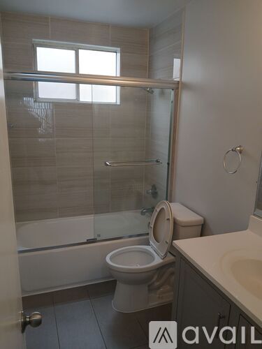 A bathroom with a toilet, sink, and shower.