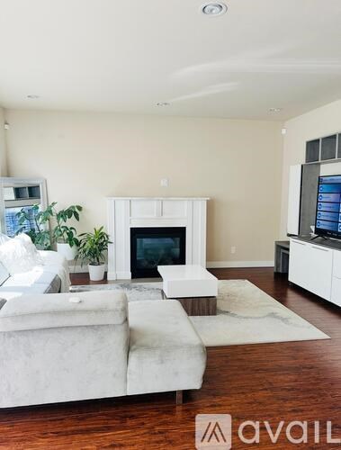 A living room with a white couch and a fireplace.